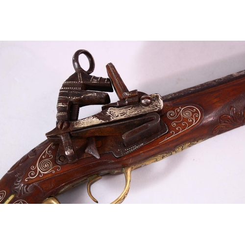 605 - AN 18TH CENTURY INDIAN FLINTLOCK PISTOL, with silver inlaid barrel, well carved wooden stock with si... 