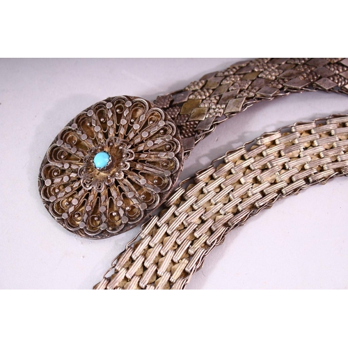 643 - AN EASTERN WHITE METAL BELT, the oval filigree buckle mounted with a turquoise cabouchon stone, 80cm... 