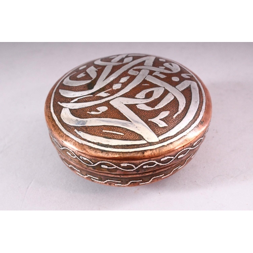 647 - AN ISLAMIC CIRCULAR COPPER BOX AND COVER, the cover with silver inlaid calligraphy, 10cm diameter.