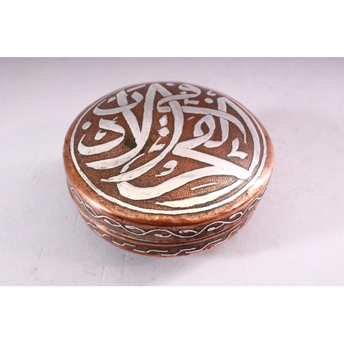 647 - AN ISLAMIC CIRCULAR COPPER BOX AND COVER, the cover with silver inlaid calligraphy, 10cm diameter.