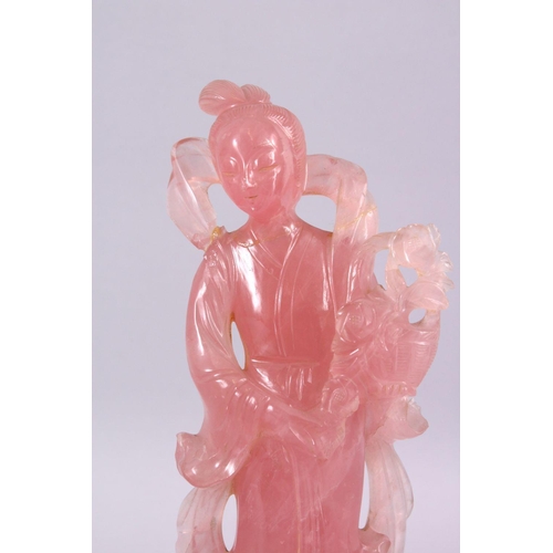 67 - A CHINESE CARVED ROSE QUARTZ FIGURE OF GUANYIN, stood holding a bouquet of flora, on a carved wooden... 