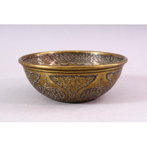 677 - A SMALL ISLAMIC CIRCULAR BRASS BOWL with silver inlaid and engraved decoration, 13cm diameter.