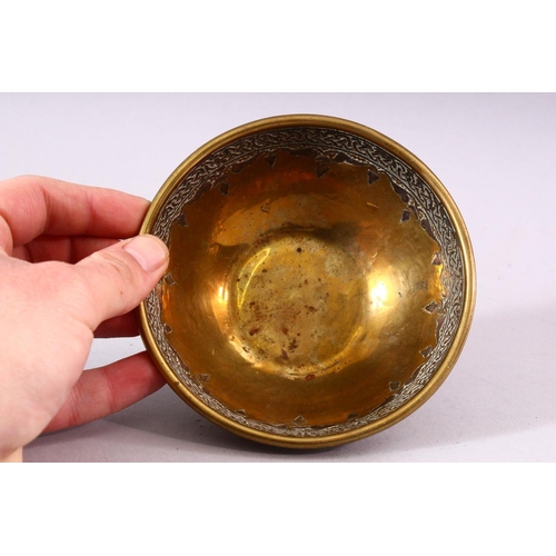 677 - A SMALL ISLAMIC CIRCULAR BRASS BOWL with silver inlaid and engraved decoration, 13cm diameter.