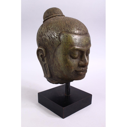 709 - A CAMBODIAN CARVED STONE BUST OF A MAN, mounted on a plinth base, overall height 28cm.