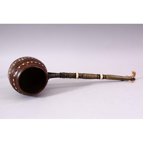 741 - AN UNUSUAL 19TH CENTURY COCONUT WATER SCOOP, with horn handle and bone inlaid decoration, 33cm long.