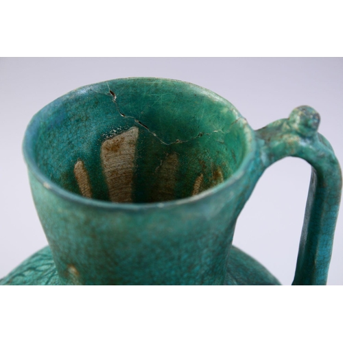 762 - A GOOD EARLY ISLAMIC TURQUOISE GLAZED POTTERY JUG, 22cm high.