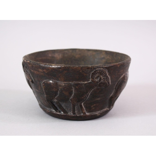 766 - AN EARLY SUMERIAN POTTERY RAM BOWL, with relief carved rams, 13cm