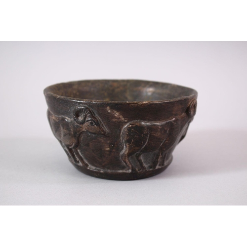 766 - AN EARLY SUMERIAN POTTERY RAM BOWL, with relief carved rams, 13cm