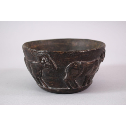 766 - AN EARLY SUMERIAN POTTERY RAM BOWL, with relief carved rams, 13cm