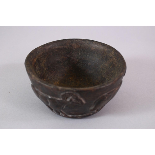 766 - AN EARLY SUMERIAN POTTERY RAM BOWL, with relief carved rams, 13cm