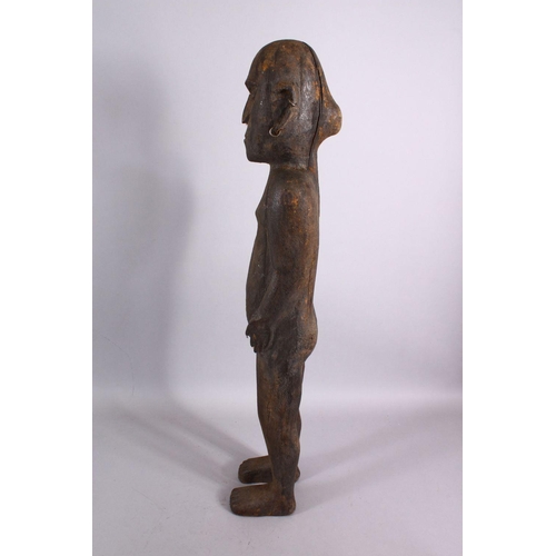 785 - AN AFRICAN CARVED WOODEN NATIVE FIGURE, with piercing's, 80cm.