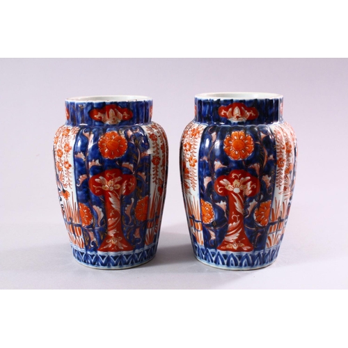 8 - A PAIR OF JAPANESE MEIJI PERIOD IMARI PORCELAIN VASES, with ribbed body, and panel decoration of ike... 