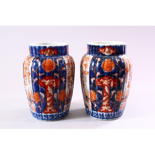 8 - A PAIR OF JAPANESE MEIJI PERIOD IMARI PORCELAIN VASES, with ribbed body, and panel decoration of ike... 