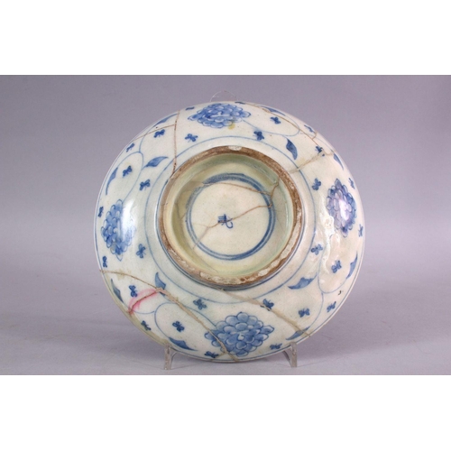 800 - AN EARLY SAFAVID BLUE & WHITE PORCELAIN PLATE, decorated with scrolling floral design, (AF) 22cm.