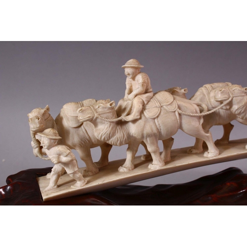 821 - AN UNUSUAL EARLY 20TH CENTURY CARVED IVORY TUSK BRIDGE, on wooden stand, carved as a group of eleven... 