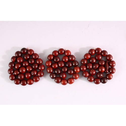 827 - THREE RED SANDLEWOOD BEAD BRACELETS and various loose beads.