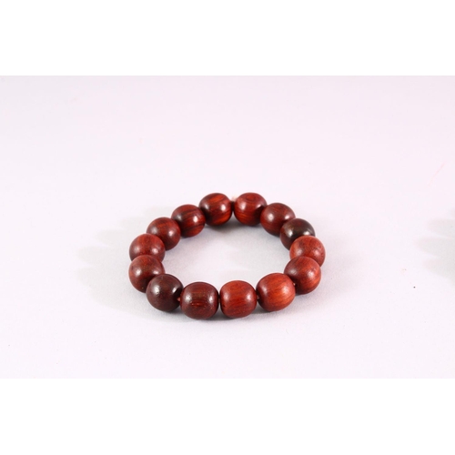 827 - THREE RED SANDLEWOOD BEAD BRACELETS and various loose beads.