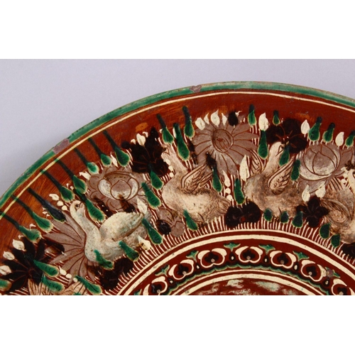 831 - A 19TH CENTURY OR EARLIER INDIAN POTTERY DISH, with poly chrome decoration depicting a multi head & ... 