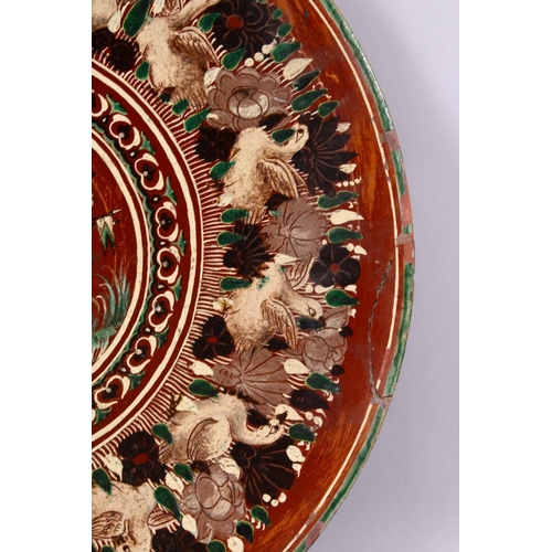 831 - A 19TH CENTURY OR EARLIER INDIAN POTTERY DISH, with poly chrome decoration depicting a multi head & ... 