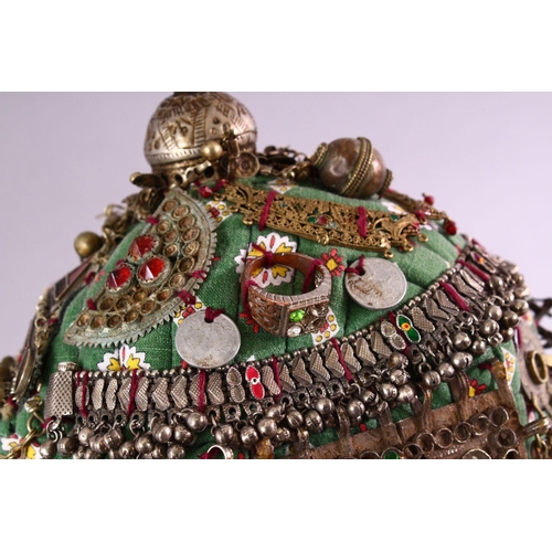 843 - A BALOCHISTAN HEAD DRESS, adorned with coins, rings, beads etc. together with associated overshirt.