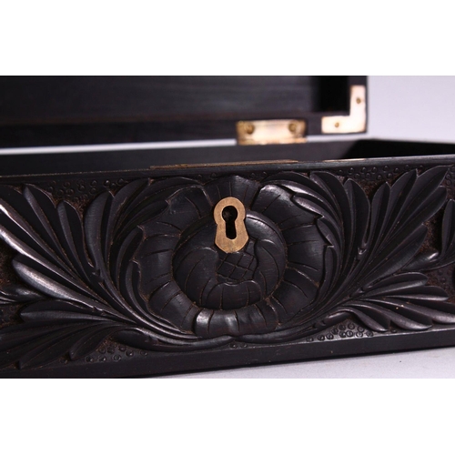 848 - A CEYLONESE CARVED EBONY CASKET, with hinged lid, 26cm long.