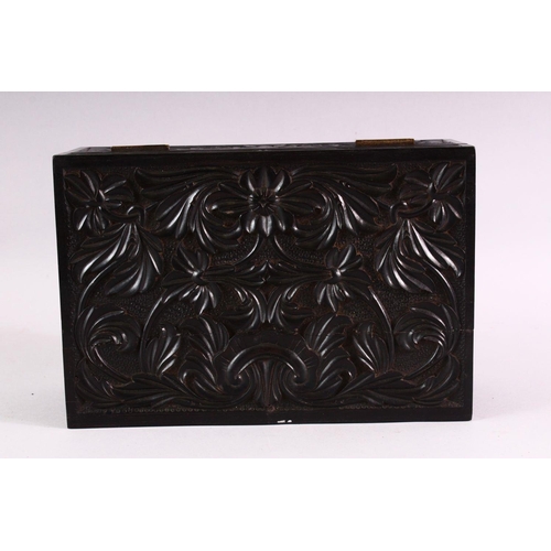 848 - A CEYLONESE CARVED EBONY CASKET, with hinged lid, 26cm long.