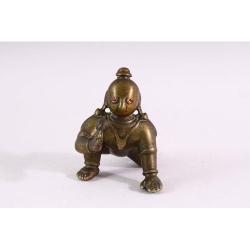 850 - A SMALL EARLY CAST BRONZE INDIAN CROUCHING FIGURE, with inset gold and ruby eyes, 9cm long.