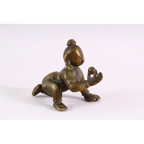 850 - A SMALL EARLY CAST BRONZE INDIAN CROUCHING FIGURE, with inset gold and ruby eyes, 9cm long.