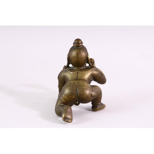 850 - A SMALL EARLY CAST BRONZE INDIAN CROUCHING FIGURE, with inset gold and ruby eyes, 9cm long.