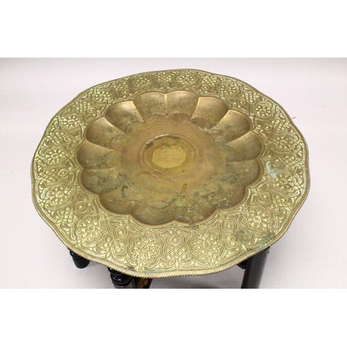 853 - A GOOD LARGE ISLAMIC BRASS TRAY TABLE AND FOLDING STAND, with embossed decoration, 76cm diameter.