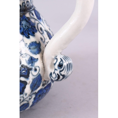 856 - AN ISLAMIC BLUE & WHITE PORCELAIN WATER JUG, decorated ith formal scrolling flora, 20cm high.