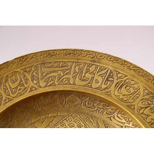 858 - A 19TH CENTURY PERSIAN ENGRAVED CALLIGRAPHIC BRASS DISH, with bands of calligraphy and temple scenes... 