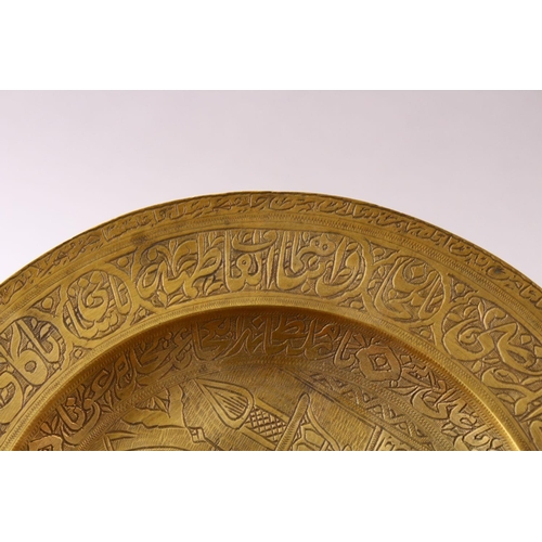 858 - A 19TH CENTURY PERSIAN ENGRAVED CALLIGRAPHIC BRASS DISH, with bands of calligraphy and temple scenes... 