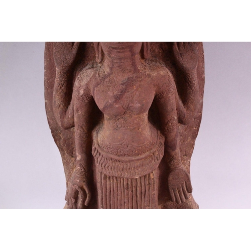 865 - A 12TH CENTURY STYLE CAMBODIAN KHMER STYLE RED SANDSTONE CARVING OF A FOUR ARMED DEITY. 52cms high.... 