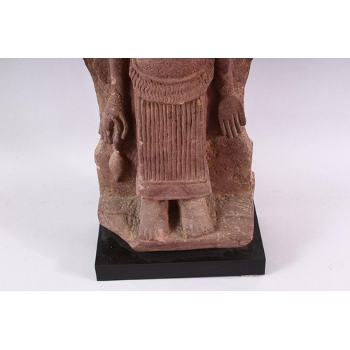 865 - A 12TH CENTURY STYLE CAMBODIAN KHMER STYLE RED SANDSTONE CARVING OF A FOUR ARMED DEITY. 52cms high.... 