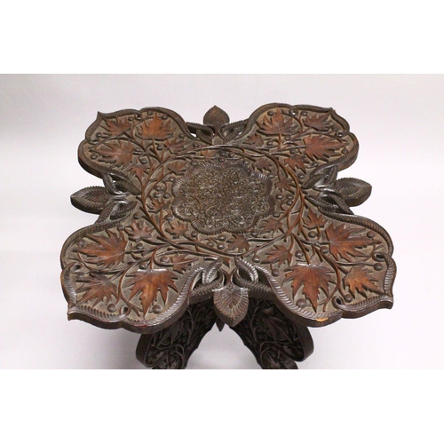 872 - A GOOD EARLY 20TH CENTURY BURMESE HARDWOOD TABLE, the shaped top and folding base, profusely carved ... 