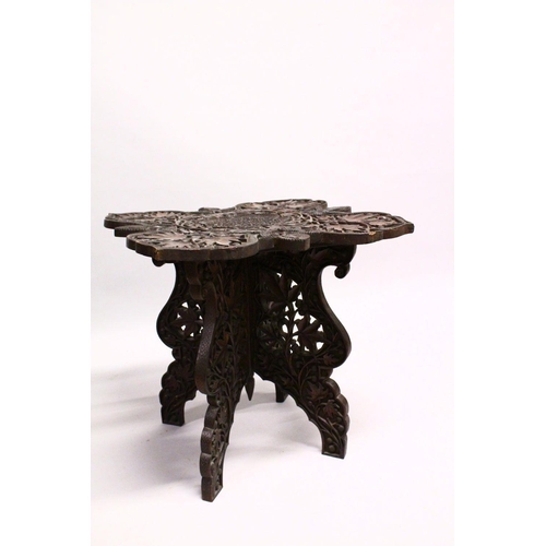 872 - A GOOD EARLY 20TH CENTURY BURMESE HARDWOOD TABLE, the shaped top and folding base, profusely carved ... 