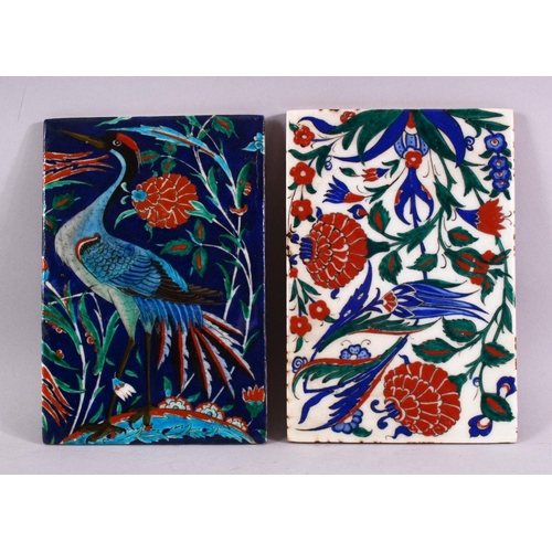 882 - TWO IZNIK TILES, one painted with a heron, one with stylised flowers, both 24cm x 16cm.