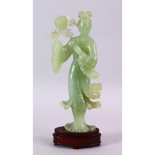 90 - A CHINESE CARVED JADE FIGURE OF GUANYIN, stood holding a bouquet above her head, on a wooden stand, ... 