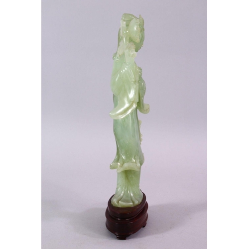 90 - A CHINESE CARVED JADE FIGURE OF GUANYIN, stood holding a bouquet above her head, on a wooden stand, ... 