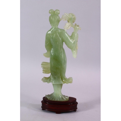 90 - A CHINESE CARVED JADE FIGURE OF GUANYIN, stood holding a bouquet above her head, on a wooden stand, ... 