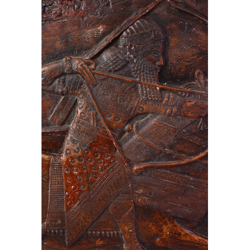 822 - A LARGE INDIAN CARVED PLASTER PANEL OF A FIGURE UPON HORSE BACK, 57cm high x 90cm wide.