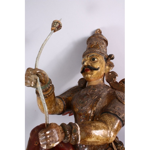 825 - A 19TH CENTURY INDIAN / BURMESE CARVED WOOD FIGURE OF A WINGED GOD, stood holding an implement, with... 