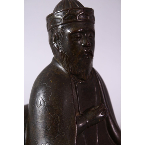 10 - AN 18TH/19TH CENTURY BRONZE SEATED FIGURE OF A SCHOLAR, on a square base, 17cm high.