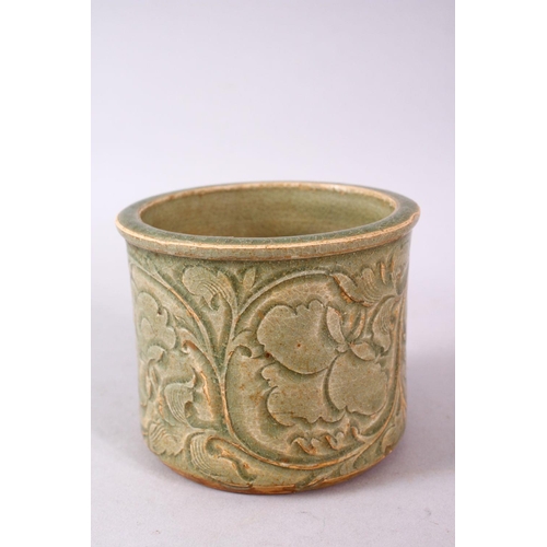 121 - A CHINESE LONGQUAN CELEDON CARVED POTTERY BRUSH WASH, carved with stylised flora, 8.5cm high, 10cm d... 