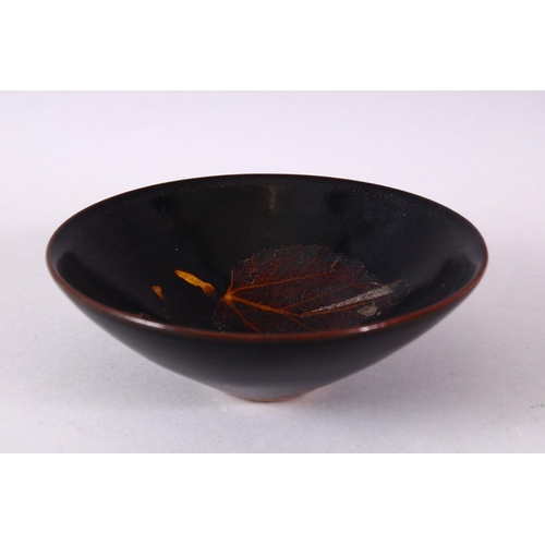 131 - A JIXHOU POTTERY CIRCULAR TEA BOWL, with dark brown glaze, the interior decorated with two leaves, 1... 