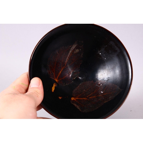 131 - A JIXHOU POTTERY CIRCULAR TEA BOWL, with dark brown glaze, the interior decorated with two leaves, 1... 