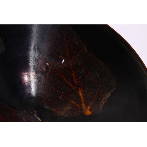 131 - A JIXHOU POTTERY CIRCULAR TEA BOWL, with dark brown glaze, the interior decorated with two leaves, 1... 