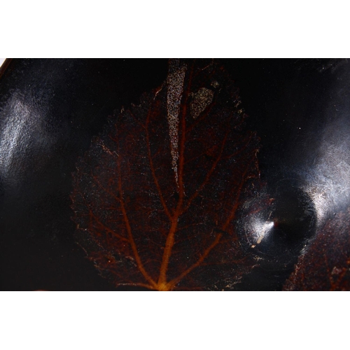 131 - A JIXHOU POTTERY CIRCULAR TEA BOWL, with dark brown glaze, the interior decorated with two leaves, 1... 