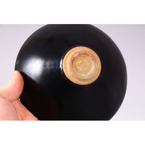 131 - A JIXHOU POTTERY CIRCULAR TEA BOWL, with dark brown glaze, the interior decorated with two leaves, 1... 